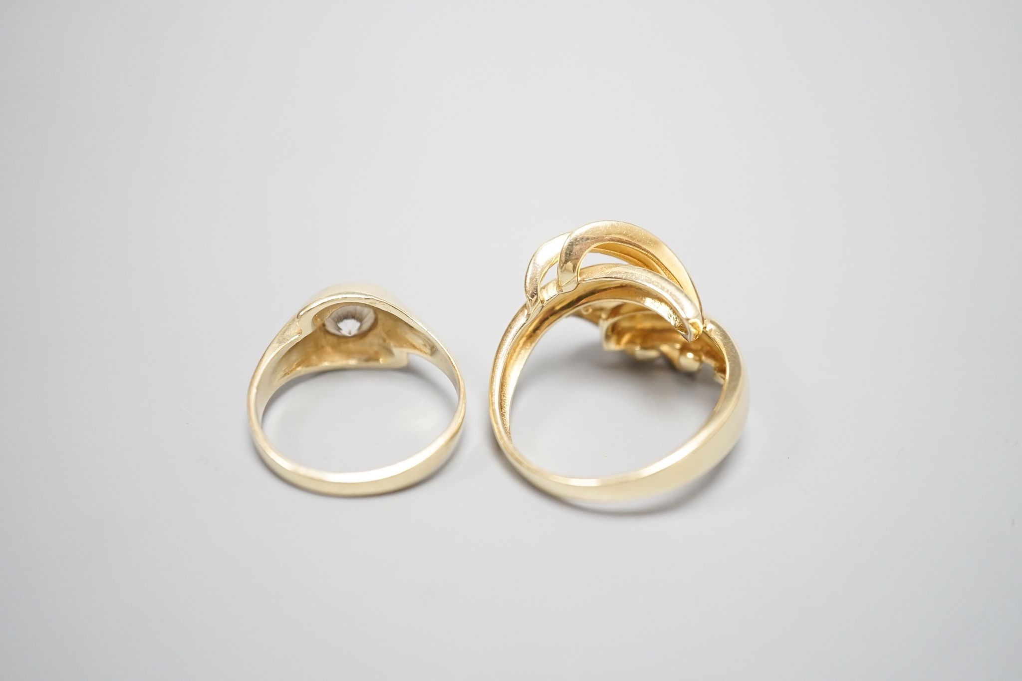 An Italian 750 scroll ring, size P, 5.5 grams and a 585 and white stone ring, gross 3.9 grams.